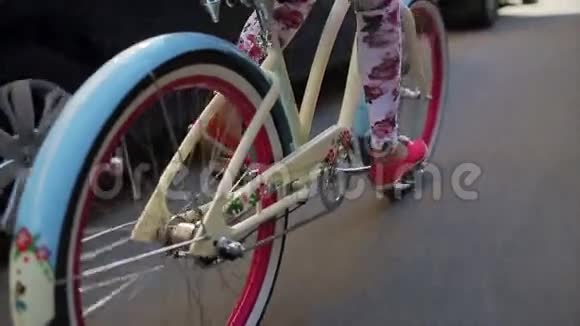 后侧的女孩骑自行车在夏季白天车轮的自行车集中在慢动作视频的预览图