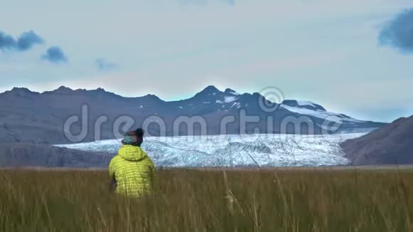 一个女人坐在草地上享受冰岛美丽的自然视频的预览图