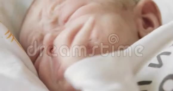睡眼的新生儿闭着脸在床上哭喊视频的预览图
