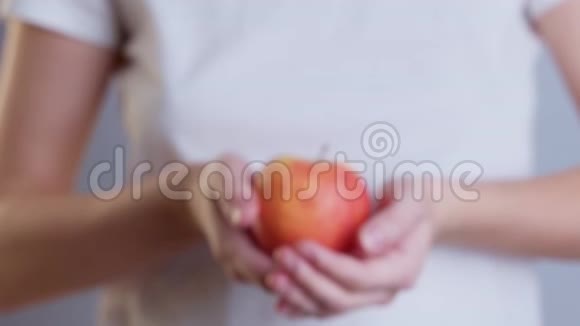 一个女人拿着一个红苹果的特写镜头视频的预览图