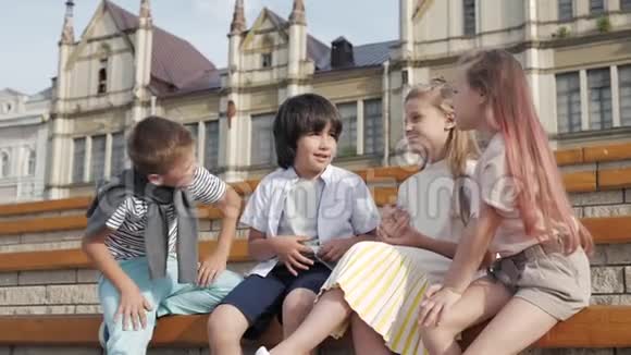 四个孩子坐在一起微笑着说话视频的预览图