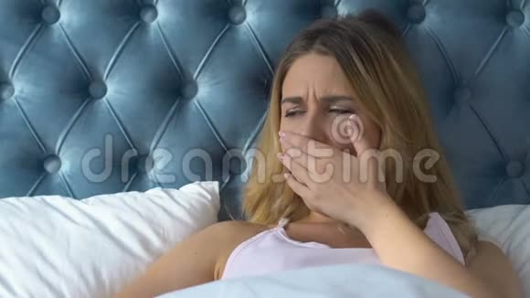 疲倦的女人躺在床上打哈欠感到困倦过敏偏头痛视频的预览图