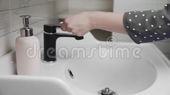 女人转动浴室水龙头用凝胶肥皂洗手视频的预览图