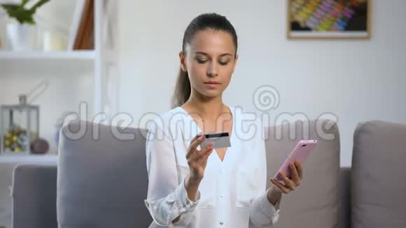 体贴的女士在智能手机购物时记住信用卡密码视频的预览图
