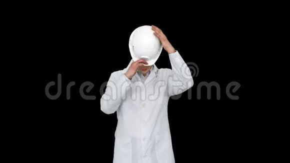 科学家工程师穿着白色长袍戴着安全帽戴着眼镜最后用眼睛做滑稽动作阿尔法频道视频的预览图