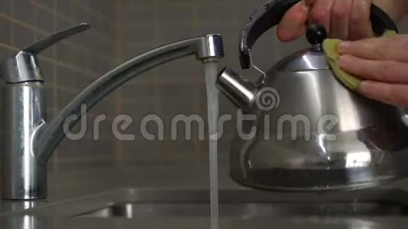 洗手池里有一只手拿着黄色海绵洗过的不锈钢水壶视频的预览图