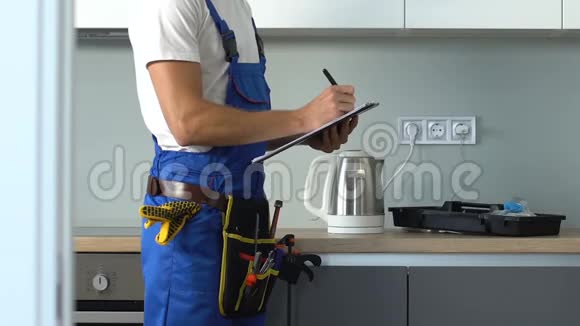 男在工作服等待名单服务调整电网在厨房视频的预览图