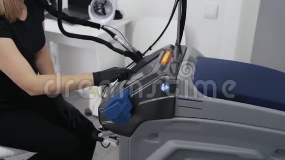侧视医生在脱毛前双手戴手套打开激光设备动作缓慢视频的预览图