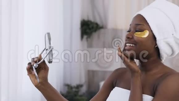 一位年轻貌美的非洲妇女头上戴着毛巾眼睛下面戴着医用金斑微笑着视频的预览图