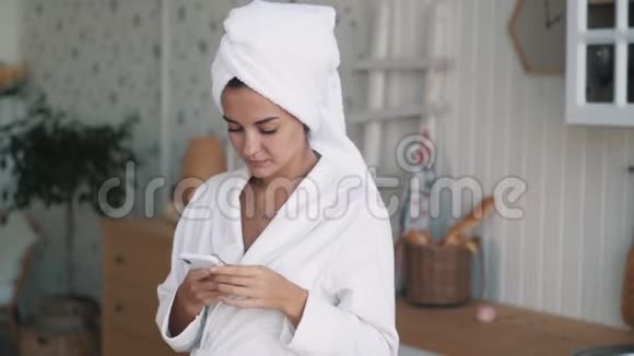头上戴毛巾的女孩在家里用电话工作动作慢视频的预览图