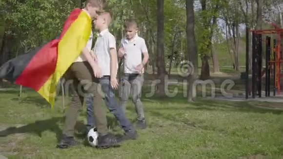 小男孩在公园里踢足球户外娱乐活动视频的预览图