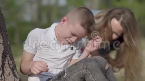 肖像小男孩在哭母亲在户外安慰她的儿子夫妻关系户外娱乐活动视频的预览图