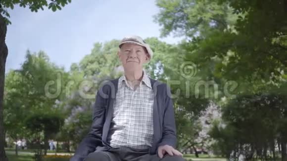 在令人惊叹的美丽公园里的老人肖像可爱的成熟祖父在阳光明媚的春天户外休息视频的预览图