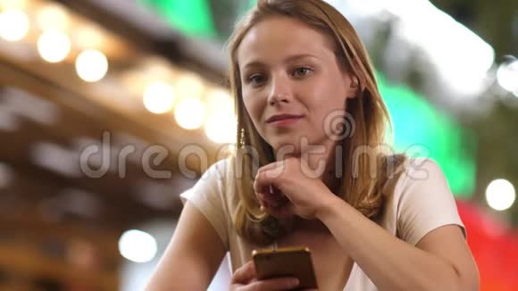 紧张的少女看着相机手里拿着一部手机视频的预览图