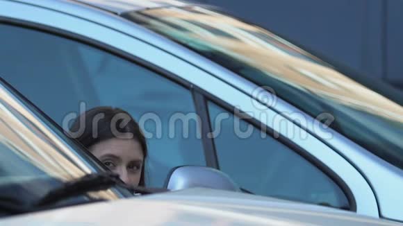 年轻女子偷偷在车后拍照小报摄影新闻视频的预览图
