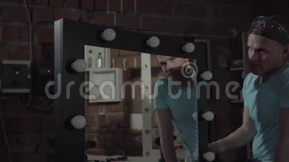肖像木匠检查镜子与灯如果它的工作或不工作手工制造工匠在车间工作视频的预览图