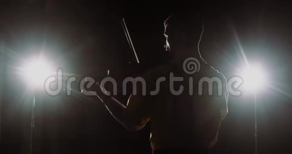 男职业小提琴手小提琴演奏聚光灯小提琴的剪影后景视频的预览图