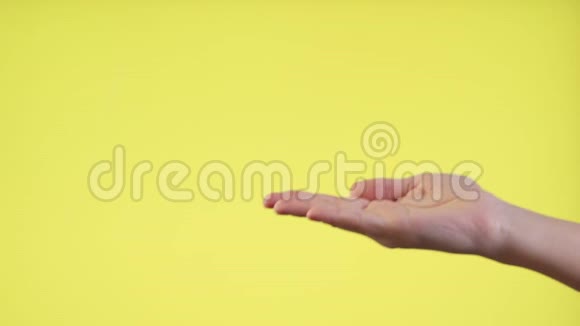 女人的手握着手掌上的铜空间孤立在黄色背景上视频的预览图