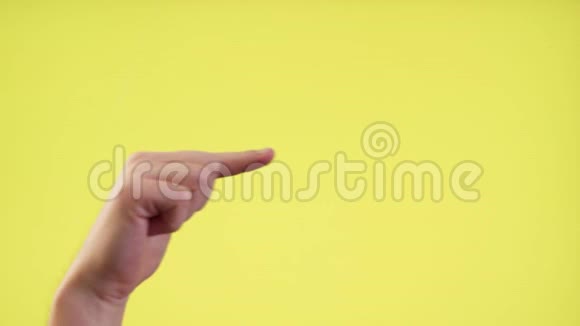 手指在黄色背景上的特写视频的预览图