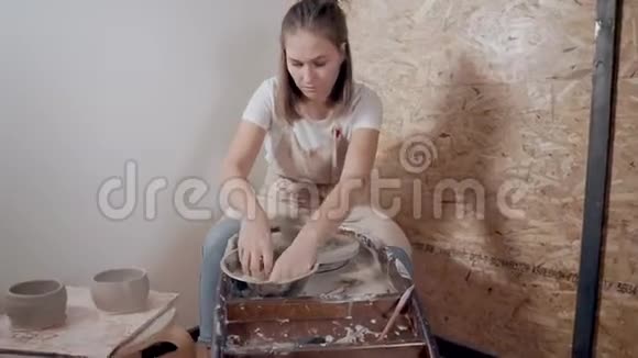 Ceramist女主人用传统的陶工轮子做餐具视频的预览图