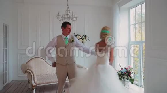 女孩和男人在一个美丽明亮的房间里跳舞一对美丽的情侣相爱年轻人视频的预览图