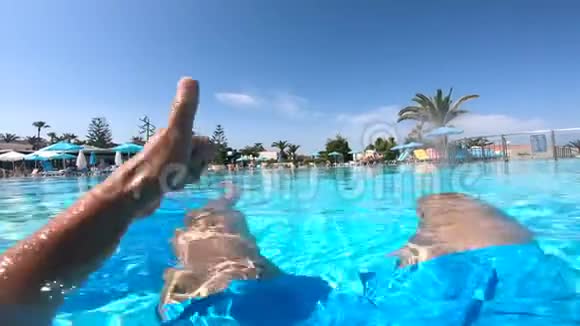 人们坐在酒店附近的游泳池里竖起大拇指暑假概念视频的预览图