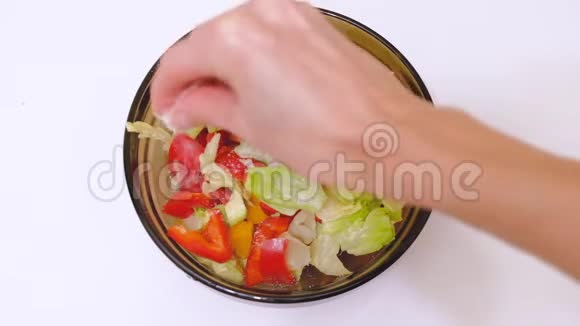 素食蔬菜沙拉玻璃碗女性手加盐视频的预览图