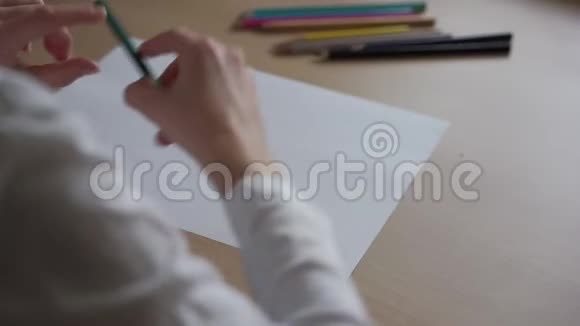 穿白衬衫的女孩把松树画在纸上视频的预览图