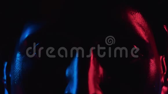 在蓝色和红色的霓虹灯中关闭阿波罗雕像的黑色石膏头视频的预览图