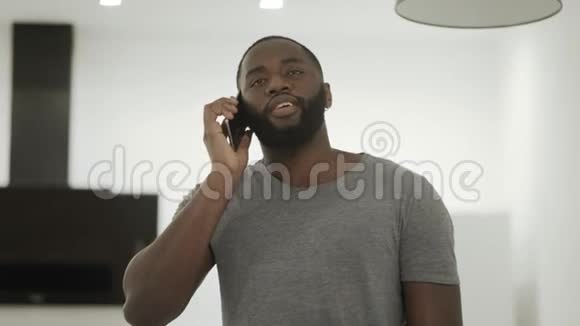 在家里的厨房里用黑色电话失望的家伙完成电话通话视频的预览图
