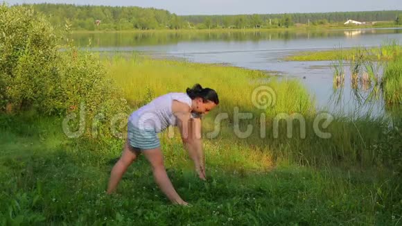 布鲁内特女士早上在湖边做倾斜运动视频的预览图