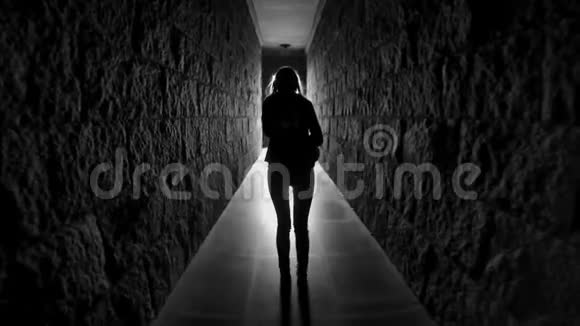 留着长发的女孩背着她走在黑暗的走廊隧道里视频的预览图