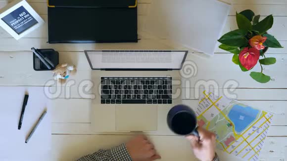 无法辨认的人喝咖啡并继续在项目上工作男性手臂在白色笔记本电脑键盘上输入文字视频的预览图