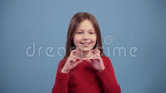 有趣的长发女孩在蓝色背景下交叉手指希望幸运兴奋但担心然后视频的预览图
