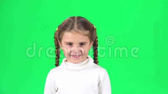可爱的女孩微笑着在工作室的绿色屏幕上尖叫慢动作视频的预览图