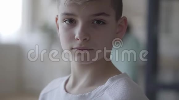近脸的一个年轻男子可爱英俊少年严肃男孩看着镜头一个没有感情的白人男孩视频的预览图