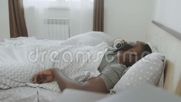 睡过头的男人在卧室起床手里拿着警报的年轻人视频的预览图