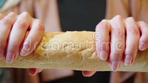 女人用双手特写慢动作打破美味的面包视频的预览图