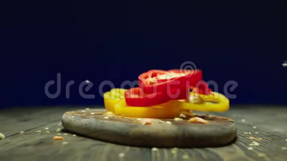 红黄椒在切割板上慢慢落下视频的预览图