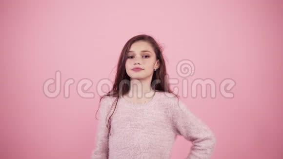迷人的长发女孩发出一个空气吻孤立在粉红色的背景白人儿童正面肖像视频的预览图