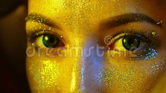 特写女孩脸上有金色的火花眼睛绿色镜片视频的预览图