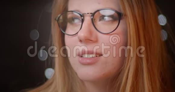 金发模特在眼镜上有明亮的妆容微笑着在bokeh背景上用相机调情视频的预览图