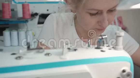 车间电动机器上金发女人缝纫视频视频的预览图