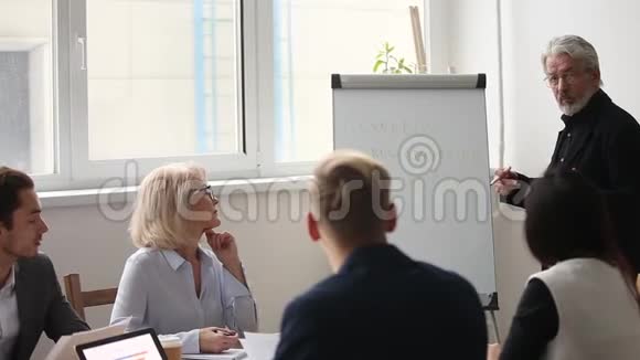 成熟的灰发商业教练向执行经理介绍视频的预览图