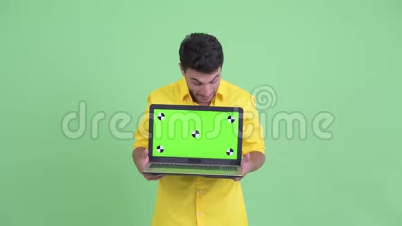 快乐年轻的西班牙裔商人一边说一边展示笔记本电脑视频的预览图