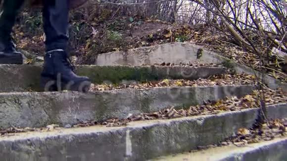 在城市公园寒冷的秋天女靴从楼梯上走下来库存录像穿上黑色皮鞋视频的预览图
