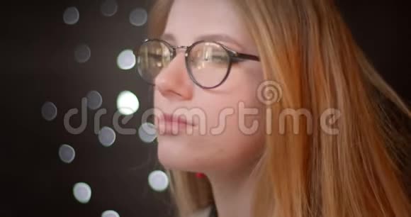 金发模特戴着明亮化妆的眼镜在bokeh背景下对着镜头高兴地微笑视频的预览图
