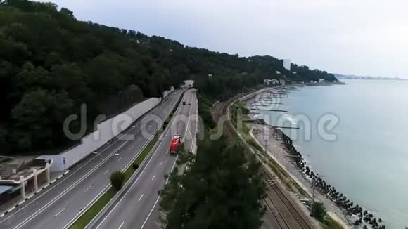 从空中可以看到一辆卡车在沿着海岸行驶的道路和铁路运输概念场景汽车在前进视频的预览图
