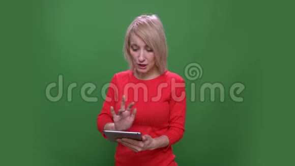 中年短发女商人专心致志地工作平板电脑孤立在绿色的色度背景上视频的预览图