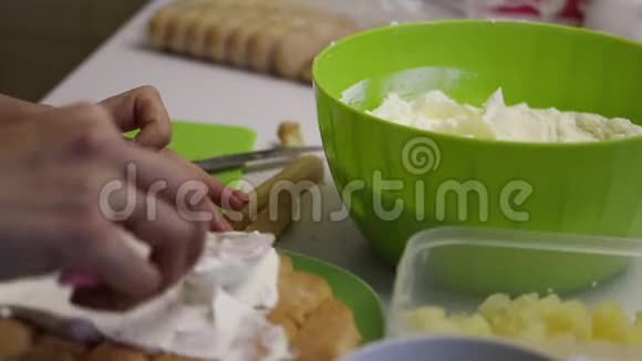 一个女人用萨沃亚迪饼干做蛋糕连续润滑饼干靠近菠萝和奶油视频的预览图